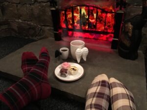 Warming feet in front of a cosy fireplace with hot cocoa 